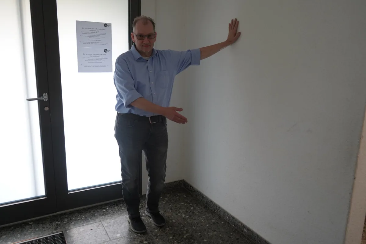 Man sieht einen Mann im Hauseingang stehen.